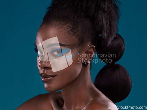 Image of Portrait, hair and makeup with an african woman in studio on a blue background for beauty or cosmetics. Face, haircare and fashion with an attractive young female model posing for natural style