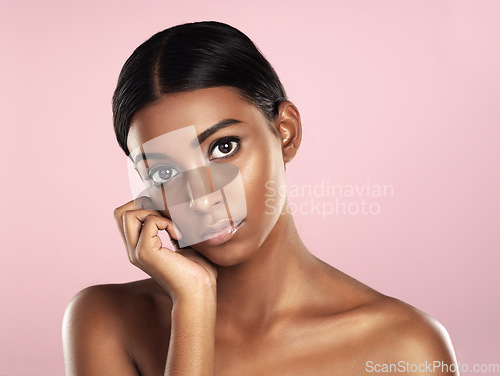 Image of Face portrait, skincare and serious woman in studio isolated on a pink background. Natural beauty, aesthetic and Indian female model with makeup, cosmetics or spa facial treatment for healthy skin.