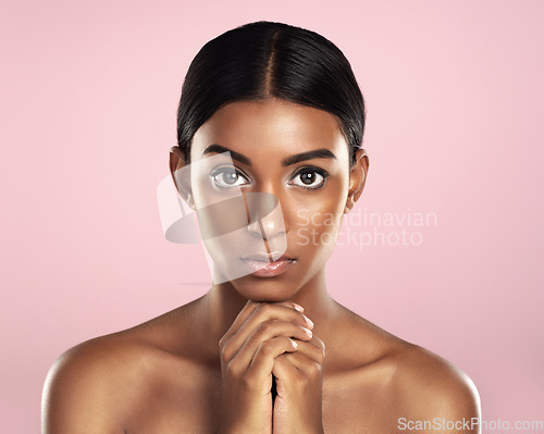 Image of Face portrait, skincare and serious woman in studio isolated on a pink background. Natural beauty, aesthetic and Indian female model with makeup, cosmetics and spa facial treatment for healthy skin.