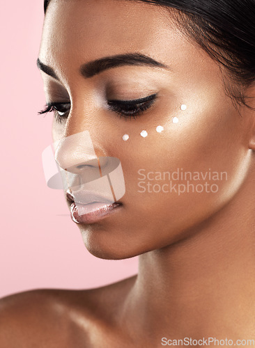 Image of Face, skincare cream and woman in studio isolated on a pink background. Dermatology, creme and Indian female model with cosmetics, sunscreen lotion or moisturizer product for healthy skin and beauty.