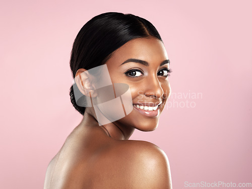 Image of Face, skincare and smile of woman in studio isolated on a pink background mockup space. Natural beauty, portrait and Indian female model with makeup, cosmetics or spa facial treatment for skin health