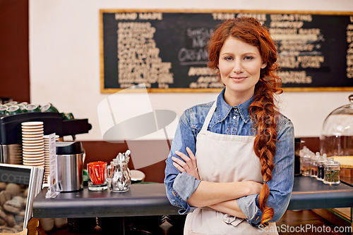 Image of Portrait, woman and barista with arms crossed, cafe and happiness with startup success, business and growth. Face, female employee and happy entrepreneur in a coffee shop, restaurant and development