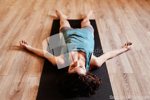 Image of Woman, yoga and sleeping on floor for rest, peace and mindfulness in gym, fitness studio or class. Girl, meditation and relax for wellness, training and zen mindset for faith, balance or self care