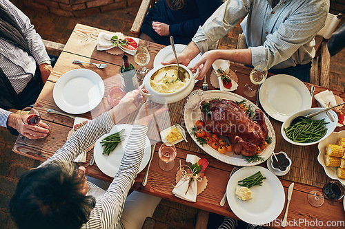 Image of Food, table and family eating together for holiday celebration or dinner party with health vegetables. Above group of people or friends hands sharing lunch meal, chicken or turkey with wine drinks