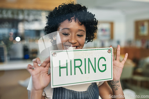 Image of Happy woman, hiring sign and window at cafe in small business for growth, advertising or billboard. African female person at restaurant holding board for hire message or recruiting at coffee shop