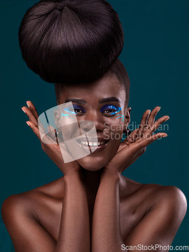 Image of Portrait, hands and makeup with an african woman in studio on a blue background for beauty or cosmetics. Face, hair or fashion with a happy and attractive young female model at the salon for style