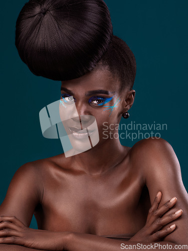 Image of Portrait or head and shoulders makeup with a black woman in studio on a blue background for hair or cosmetics. Face, haircare and fashion with an attractive young female model at the salon for style