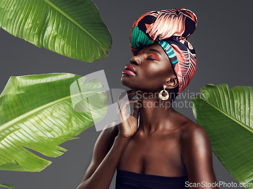 Image of Black woman in African turban, fashion with leaves and beauty with makeup on studio background. Natural cosmetics, nature aesthetic and female model with traditional head wrap, creativity and style