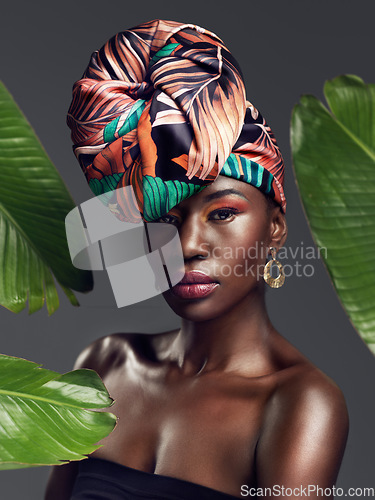 Image of Black woman in portrait in African turban, leaves and fashion with makeup and beauty on studio background. Natural cosmetics, nature aesthetic and female model on traditional head wrap with style