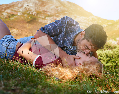 Image of Relax, kiss and love with couple in nature for carefree, bonding and affectionate. Happiness, date and romance with man and woman cuddling in grass field for summer break, happy and relationship