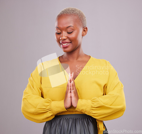 Image of Hands together, smile and black woman with prayer, hope and religious belief against a grey studio background. Female person, worship and model with hand gesture, happiness and faith with wellness