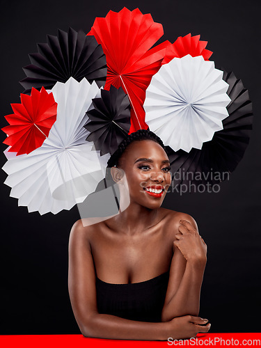 Image of Smile, thinking and black woman with origami fans, beauty and confident lady against a black background. Female person, model and girl with paper art, creativity and glamour with ideas and fantasy