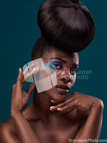 Image of Portrait, beauty and hair with an african woman in studio on a blue background for makeup or cosmetics. Face, haircare and fashion with an attractive young female model at the salon for trendy style