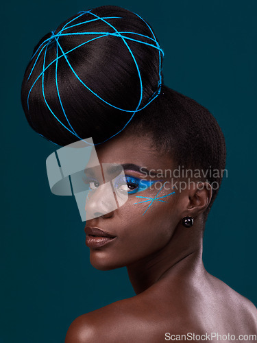 Image of Portrait, hair and back with a model black woman in studio on a blue background for beauty. Face, haircare and makeup with an attractive young female person looking over her shoulder at the salon