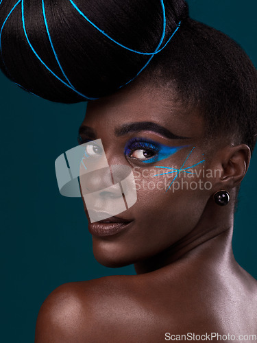 Image of Portrait, hair and rear view with a model black woman in studio on a blue background for beauty. Face, fashion and makeup with an attractive young female person looking over her shoulder at the salon
