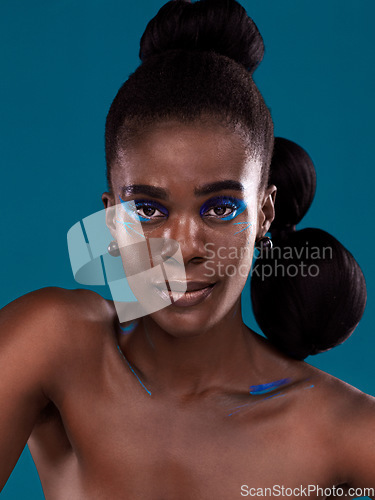 Image of Portrait, makeup and hair care with a black woman in studio on a blue background for natural cosmetics. Face, beauty and contemporary fashion with a beautiful female model posing for trendy style
