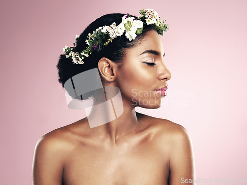 Image of Woman, flowers and hair crown for beauty in studio, pink background and natural skincare glow. African face, female model and floral headband of plants, sustainable cosmetics and eco friendly makeup