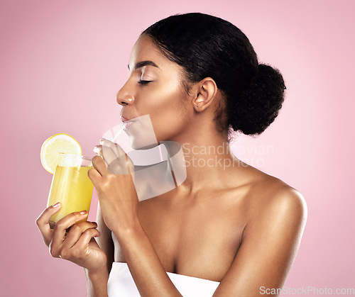 Image of Woman, orange juice drink and glass in studio, pink background or detox for healthy weight loss. African model, citrus smoothie and vitamin c fruits for nutrition benefits, natural beauty or wellness