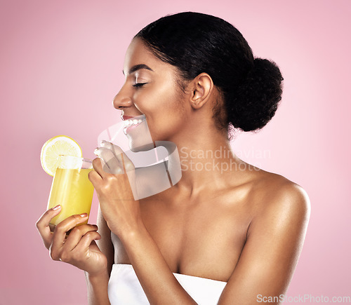 Image of Happy woman, healthy orange juice and glass in studio, pink background and detox for weight loss. African model, citrus smoothie and vitamin c fruits for vegan nutrition, diet drink or natural beauty