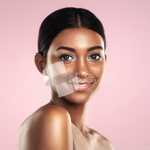 Image of Face, skincare and smile of woman in studio isolated on a pink background mockup. Portrait, natural beauty and Indian female model with makeup, cosmetics and spa facial treatment for healthy skin.