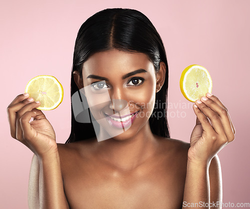 Image of Face, skincare and happy woman with orange slices in studio isolated on a pink background. Fruit, natural cosmetics and portrait of Indian female model with food for detox, nutrition and vitamin c.