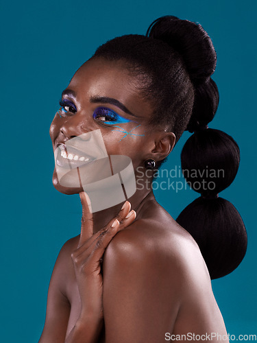 Image of Portrait, smile and makeup with a model black woman in studio on a blue background for hair or cosmetics. Face, happy and fashion with an attractive young female person posing to promote beauty