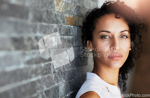 Image of Portrait, serious and woman against a brick wall, thinking and focus with thoughts, future and informal. Face, female person and confident girl with assertive look, casual outfit and attractive lady