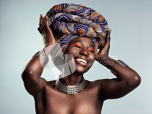 Image of Beauty, black woman and laughing with African turban and smile in a studio. Isolated, grey background traditional makeup with a young female model with culture crown and fashion with cosmetics
