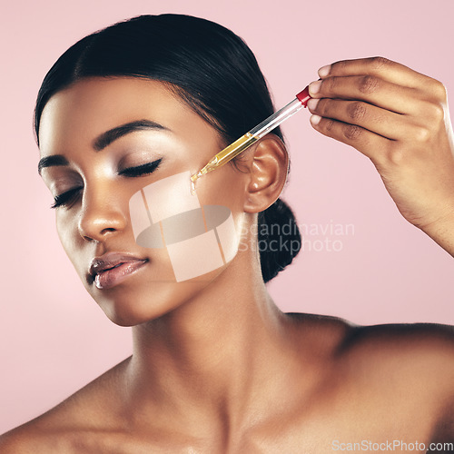 Image of Face, skincare serum and woman with eyes closed in studio isolated on a pink background. Dermatology, cosmetics and Indian model with hyaluronic acid, essential oil or vitamin a for healthy skin.