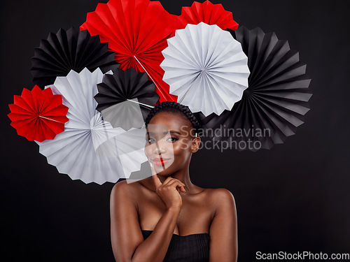 Image of Beauty, portrait and black woman with origami fans in studio isolated on a dark background. Face, makeup cosmetics and skincare of female model with traditional Japanese paper art for culture hat.