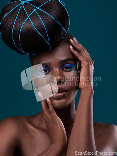 Image of Portrait, hands and hair with a model black woman in studio on a blue background for beauty. Face, haircare and cosmetics with an attractive young female person touching her skin at the styling salon