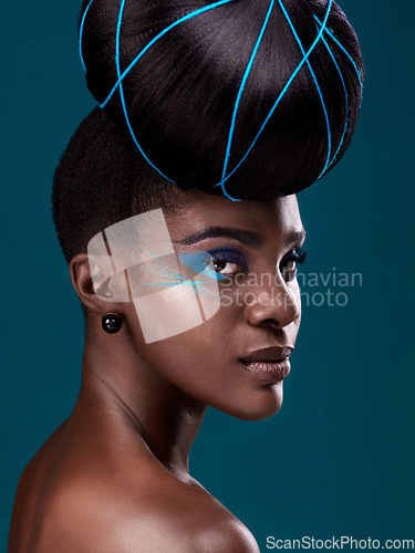 Image of Portrait, hair and makeup with a serious black woman in studio on a blue background for beauty. Face, haircare and cosmetics with an attractive young female model at the salon for fashion or styling