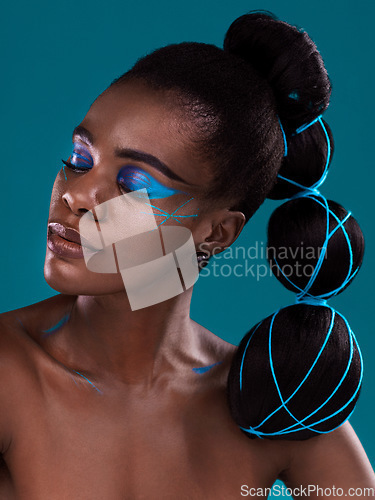 Image of Face, beauty and makeup with an african woman in studio on a blue background for hair or cosmetics. Eye shadow, haircare and fashion with an attractive young female model at the salon for style