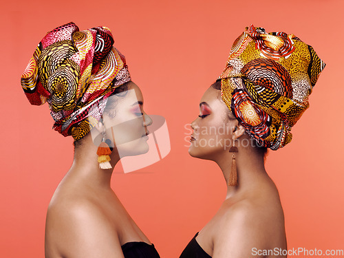 Image of African fashion, beauty and profile of women on orange background with cosmetics, makeup and accessories. Glamour, luxury and female people with exotic jewelry, traditional style and scarf in studio