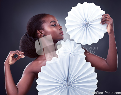 Image of Beauty, fashion and black woman with origami, stylish and confident against a dark studio background. Female person, model or girl with trendy outfit, paper and glamour with elegant clothes and style