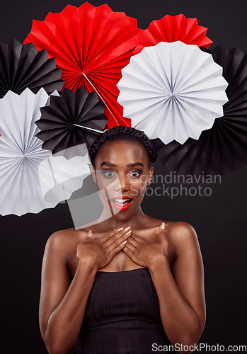 Image of Portrait, surprise and black woman with origami fans, makeup and beauty against a black background. Face, female person and model with paper art, creative and announcement with fashion and creativity