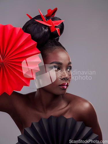 Image of Beauty, makeup and origami with black woman in studio for creative, art and culture. Traditional, cosmetics and paper design with female model and fans on grey background for oriental, retro or color