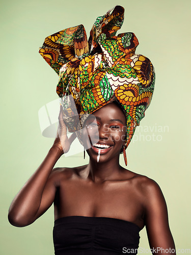 Image of Beauty, black woman and portrait with African head scarf and smile in a studio. Isolated, green background traditional Africa wrap with a young female model with culture and pride with cosmetics