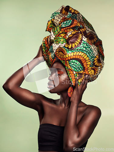 Image of Culture, fashion and black woman in head wrap in studio for makeup, glow and cosmetics on green background. Face, beauty and african female model with pride, tradition and confidence isolated