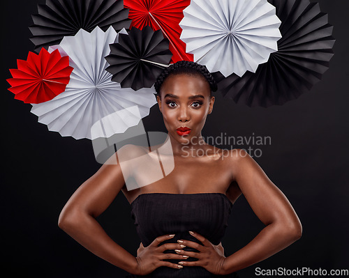 Image of Face, beauty and black woman with origami fans in studio isolated on a dark background. Portrait, makeup cosmetics and skincare of female model with traditional Japanese paper hat for fashion art.