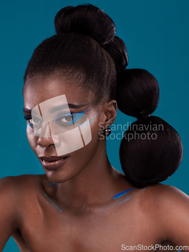 Image of Portrait, makeup and bold with a model black woman in studio on a blue background for hair or cosmetics. Face, confidence and fashion with an attractive young female person posing to promote beauty