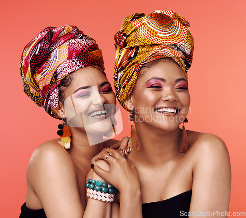 Image of African fashion, friends and women laugh on orange background with cosmetics, makeup and accessories. Glamour, luxury and face of female people with exotic jewelry, traditional style and head scarf