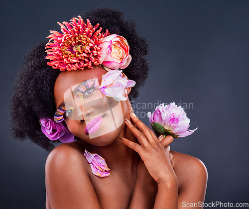 Image of Beauty, flowers and black woman in studio for makeup, creative and organic on black background. Floral, body care and african female model pose with eco friendly, natural and cosmetics with mockup