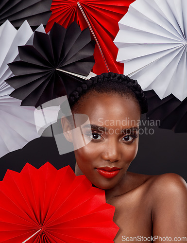 Image of Portrait, makeup and black woman with origami fans, beauty and confident girl against black background. Face, female person or model with paper art, artistic and creativity with cosmetics and fantasy