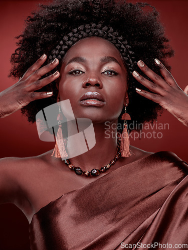 Image of Portrait, beauty and black woman with fashion in studio isolated on a red background. Face, makeup cosmetics and confident African model with stylish outfit, traditional headband or culture aesthetic