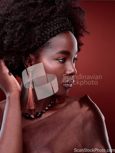 Image of Thinking, natural beauty and black woman with fashion in studio isolated on a red background. Aesthetic, makeup cosmetics and serious African model with stylish outfit, traditional jewelry or culture