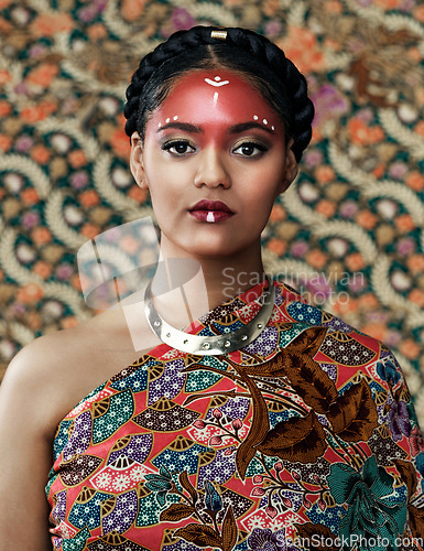 Image of Makeup, portrait and a woman with fashion for culture isolated on a studio background or wall. Face paint, tribal goddess and a young model with traditional, cultural or clothes for a celebration