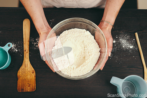 Image of Woman, hands and bowl of flour for baking above with ingredients or recipe on kitchen counter at home. Top view of female person or baker hand holding mixture or batter for delicious pastry in house