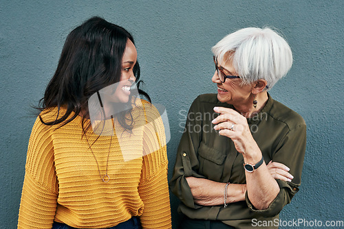 Image of Senior businesswoman, break and conversation with employee, friend or colleague in discussion outside work on blue background. Women, talking and happy together or black woman, mature person smile