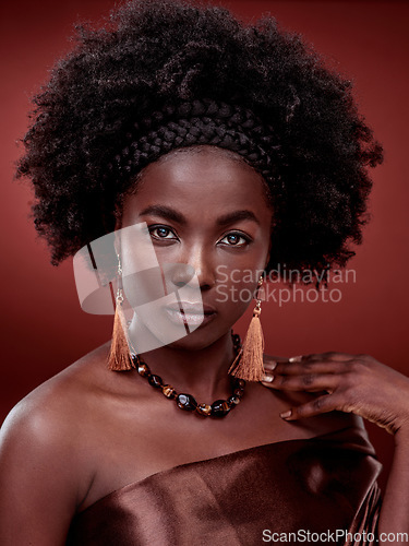 Image of Beauty, portrait and black woman with fashion in studio isolated on a red background. Face, makeup cosmetics and serious African female model with stylish outfit, traditional earings and jewelry.